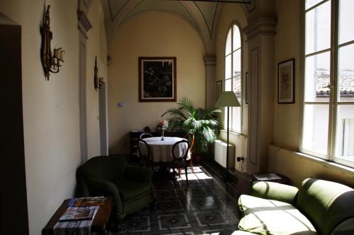 a living room with a table and chairs and windows at La Corte in Foligno