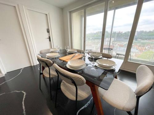 a dining room with a table and chairs with a view at Atypaluxe in Épinal