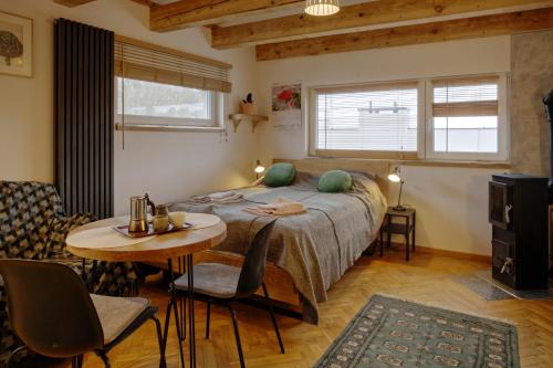 sypialnia z łóżkiem, stołem i krzesłami w obiekcie Studio w zabytkowej kamienicy w mieście Gdynia