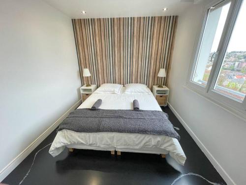 a bedroom with a large bed with two windows at Atypaluxe in Épinal