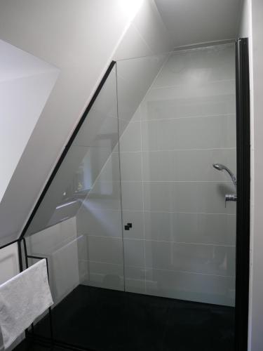 La salle de bains est pourvue d'une douche et d'une paroi en verre. dans l'établissement Villa Kerandraon, à Gouesnach