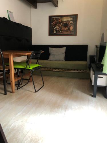 een woonkamer met een groene bank en een tafel bij La Petit Maison Elena in Sanremo