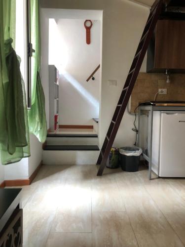 een keuken met een trap in een kamer met een vloer bij La Petit Maison Elena in Sanremo