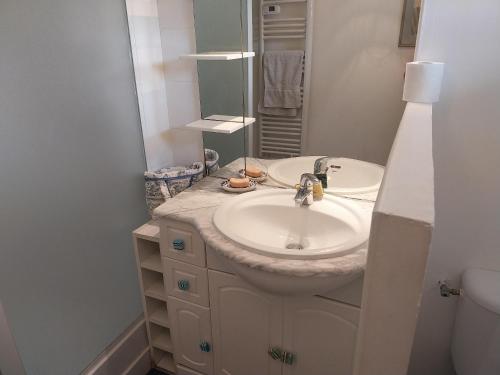 uma casa de banho com um lavatório e um espelho em LA MADRAGUE- 2P avec piscine privative em Saint-Cyr-sur-Mer