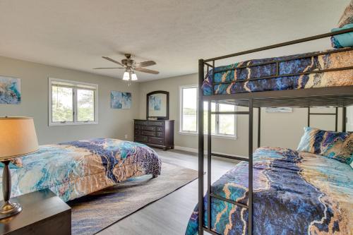 a bedroom with two bunk beds and a ceiling fan at Serene Lakefront Mountain Home Getaway with Atrium! in Mountain Home