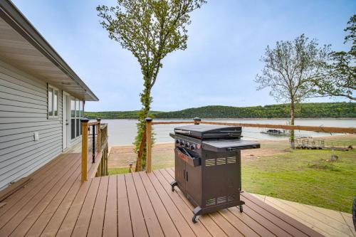 a grill on a deck with a view of a lake at Serene Lakefront Mountain Home Getaway with Atrium! in Mountain Home