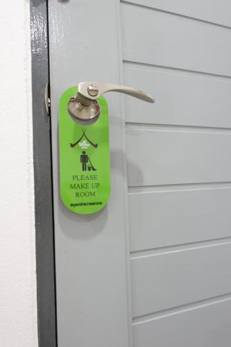 a door with a sign on it attached to it at The Gun Hotel in Surin