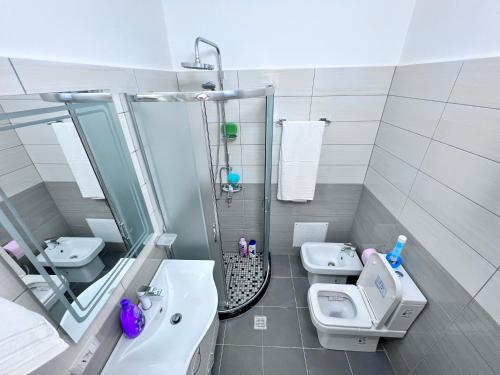 uma casa de banho com um lavatório, um WC e um chuveiro em White Luxury em Shkodër