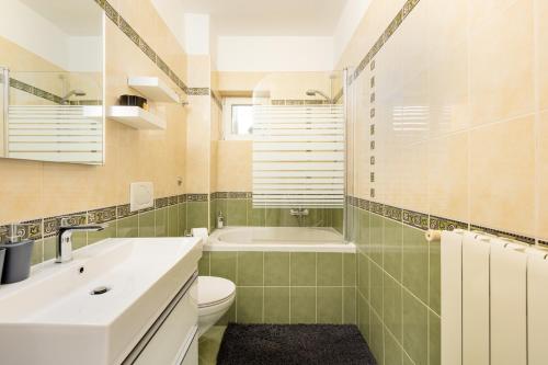 a bathroom with a sink and a toilet and a tub at Apartman Marina in Vrbnik