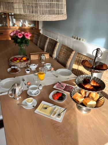 una mesa con alimentos para el desayuno encima en La Maison du Chevalier - Chambres et tables d'hôtes - adults only, en Marat