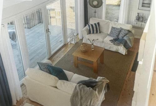 ein Wohnzimmer mit einem Sofa und einem Tisch in der Unterkunft Saltkällan Hällaviksvägen 11 in Uddevalla