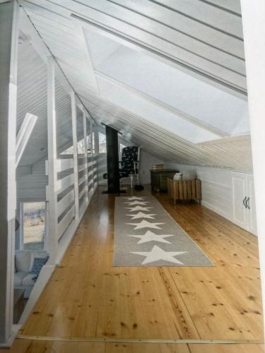 um quarto no sótão com um tecto branco e pisos em madeira em Saltkällan Hällaviksvägen 11 em Uddevalla