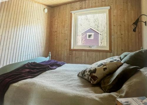 a bed in a room with a window at Saltkällan Hällaviksvägen 11 in Uddevalla