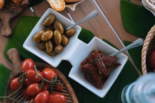 a table topped with plates of meat and vegetables at Emesh Boutique Suite in Agrigento