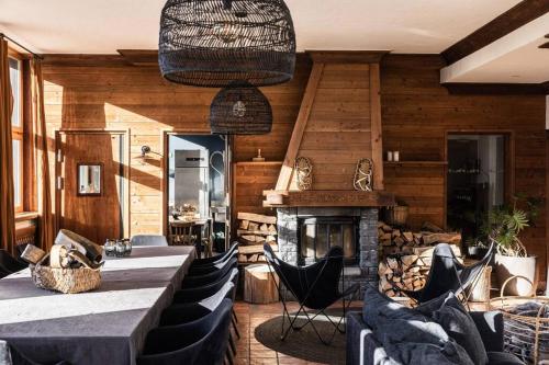 a dining room with a fireplace and a table and chairs at Chalet d'Albiez in Albiez-Montrond