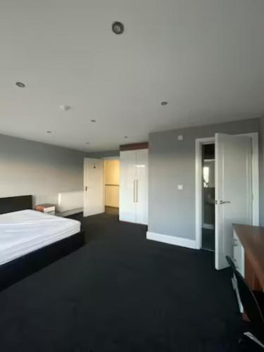 Habitación grande con cama y algunos armarios blancos. en Extra large 6 bed 7 bath townhouse in Manchester, en Mánchester
