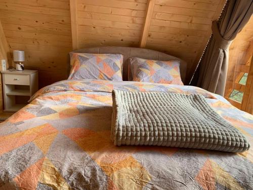 a bed with a blanket and pillows in a room at Villa Wood Borje in Žabljak