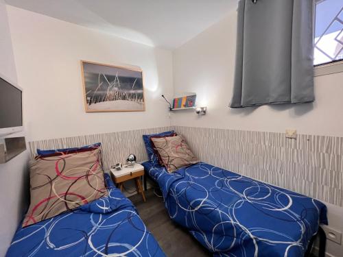 a small room with two beds and a tv at Domaine de La Coudouliere, Vue Mer, Plage, Piscine et Parc in Six-Fours-les-Plages