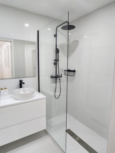 a white bathroom with a shower and a sink at Janela D’Ouro in Peso da Régua