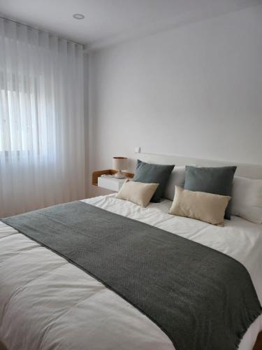 een slaapkamer met een groot wit bed met kussens bij Janela D’Ouro in Peso da Régua