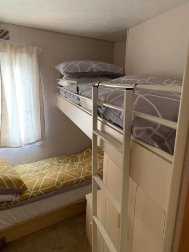 een slaapkamer met 2 stapelbedden en een raam bij Sealands in Ingoldmells
