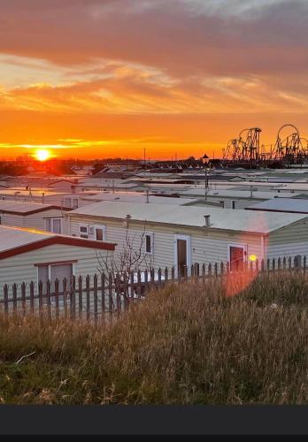 a group of buildings with the sunset in the background at Sealands in Ingoldmells