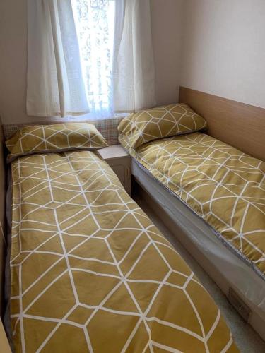 two beds sitting next to each other in a bedroom at Sealands in Ingoldmells