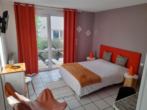 Schlafzimmer mit einem Bett und Blick auf einen Balkon in der Unterkunft Hotel de l'Ile d'Amour in Langeac