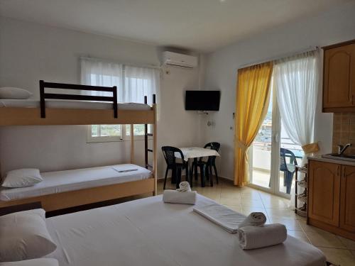 a bedroom with two bunk beds and a kitchen with a table at Studio Eno Ksamil in Ksamil