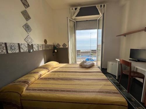 a bedroom with a large bed with a large window at Piccolo Hotel di Lavagna in Lavagna