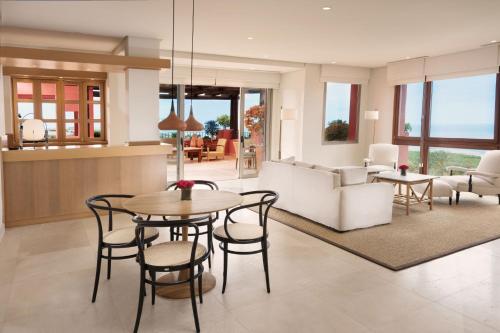 a living room with a table and chairs at The Ritz-Carlton Tenerife, Abama in Guía de Isora