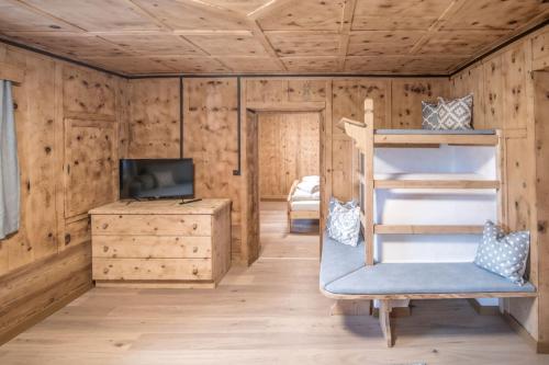 a room with a bunk bed and a desk at Pfitscherhof in Campo di Trens
