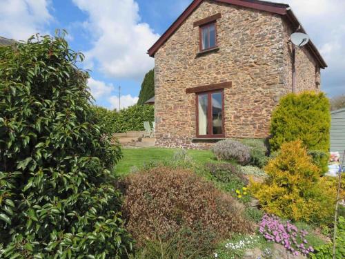 a stone house with a garden in front of it at Creedy Meadow Barn in Crediton