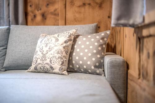 a gray couch with two pillows on it at Pfitscherhof in Campo di Trens