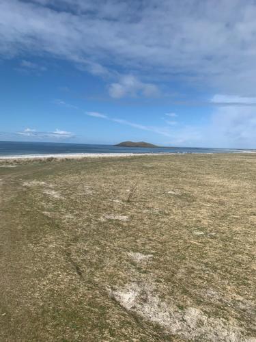 an empty field with the ocean in the background at Loch an Eilean Pod Isle of South Uist in Pollachar