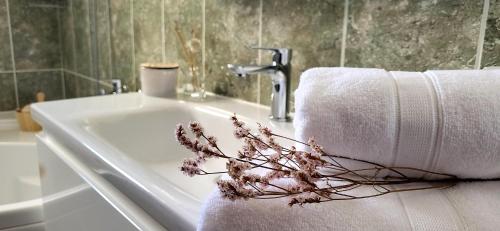a bathroom sink with towels and flowers on it at SUN apartment with SEA VIEW and shared POOL in Split
