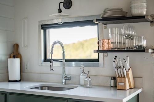 eine Küchentheke mit einem Waschbecken und einem Fenster in der Unterkunft Train Caboose & River Views Near Downtown in Lynchburg