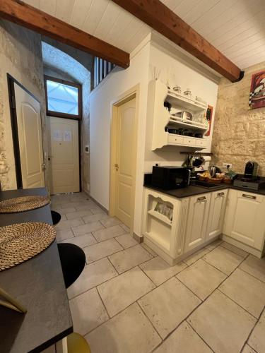 a kitchen with white cabinets and a tile floor at Maison Opéra in Bari