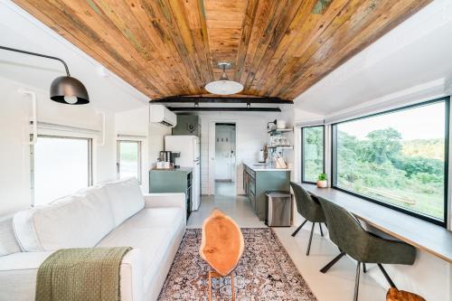 a living room with a white couch and a table at Train Caboose & River Views Near Downtown in Lynchburg