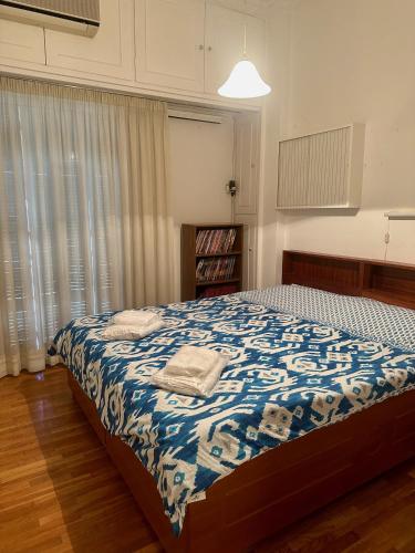 a bedroom with a bed with a blue and white blanket at Vintage-style 2 bedroom apartment at Katechaki in Athens