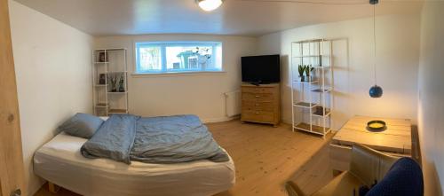 een kleine slaapkamer met een bed en een tafel bij Værelse med eget køkken og bad in Esbjerg