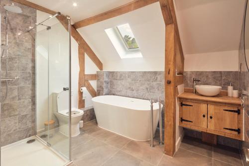 uma casa de banho com uma banheira, um WC e um lavatório. em Hayes Farm - 8 Houses em Gloucester