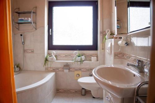 ein Badezimmer mit einer Badewanne, einem WC und einem Waschbecken in der Unterkunft Urlaub mit verglaster Terrasse in Emmingen-Liptingen
