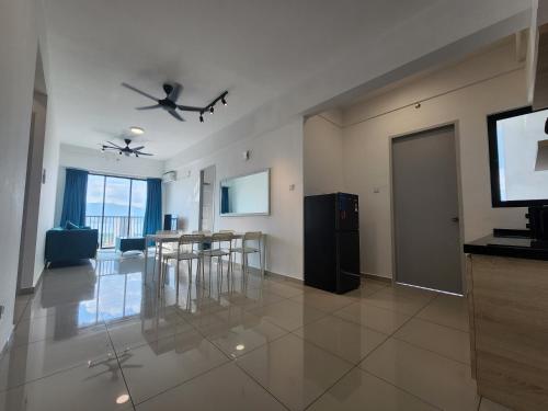 a living room with a television and a table and chairs at Praicon Executive Suite in Butterworth