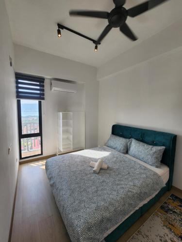 a bedroom with a large bed with a ceiling fan at Praicon Executive Suite in Butterworth