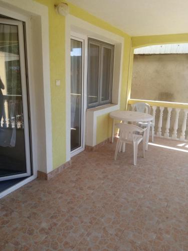 a patio with a table and chairs on a balcony at Гостевой дом Polina in Gornji Sušanj
