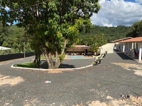 a park with a bench and a tree and a building at Pousada Saint James in Águas de Lindóia