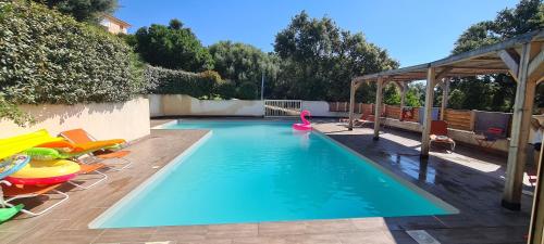 une piscine avec des chaises et une nouille de piscine rose à l'intérieur dans l'établissement Villa Maremuntagna Porto Vecchio, à Porto-Vecchio