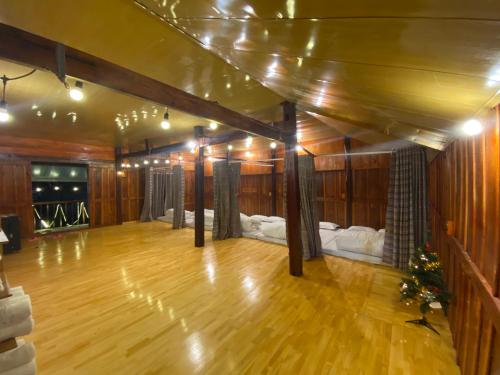 a room with a wooden floor and a room with two beds at Tuệ Nhi Homestay Ngườm Ngao Bản Giốc in Cao Bằng