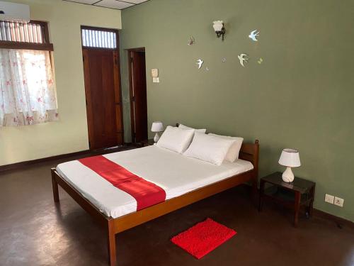 a bedroom with a bed with white and red sheets at Oasis Colombo in Colombo